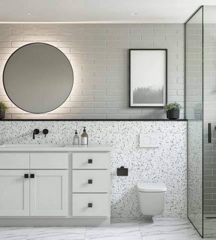 Modern bathroom featuring a circular mirror, sleek cabinetry, terrazzo wall, and a glass shower with stylish fixtures.