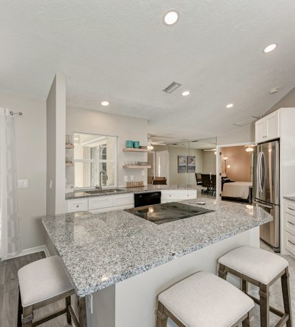 A modern kitchen featuring granite countertops and stainless steel appliances, showcasing a sleek and stylish design.