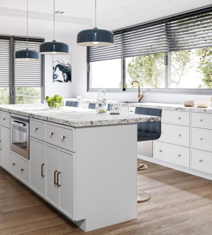 A modern kitchen featuring white cabinets and warm wooden floors, creating a bright and inviting atmosphere.