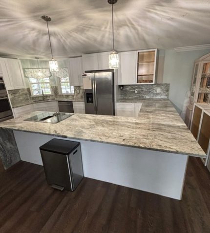 A modern kitchen featuring white cabinets and elegant granite countertops.