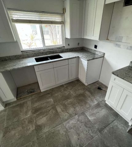 modern kitchen featuring white cabinets and elegant granite countertops.