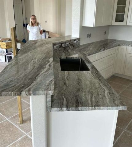 A woman stands in front of a kitchen counter