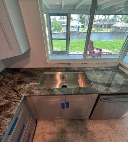 A kitchen featuring a sink and countertop, showcasing a clean and organized cooking space.