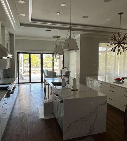 A spacious kitchen featuring a large island and a cozy dining area with modern furnishings.